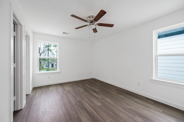 unfurnished bedroom with dark wood-style floors, visible vents, ceiling fan, and baseboards