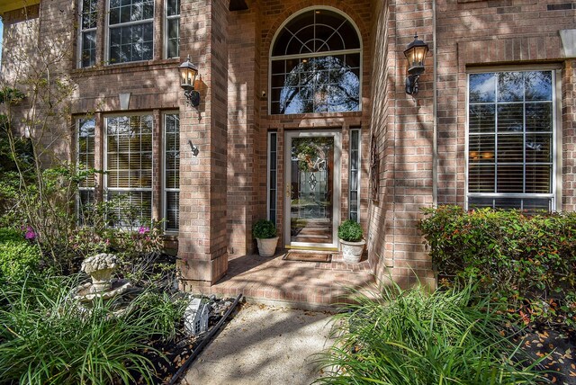 view of exterior entry featuring brick siding