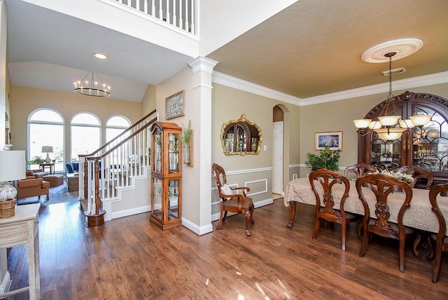 dining area with crown molding, a notable chandelier, wood finished floors, and arched walkways