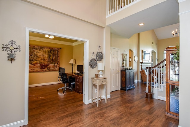 foyer featuring stairway, wood finished floors, baseboards, and high vaulted ceiling