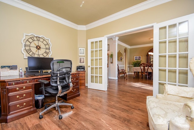 office space featuring arched walkways, ornamental molding, french doors, and wood finished floors