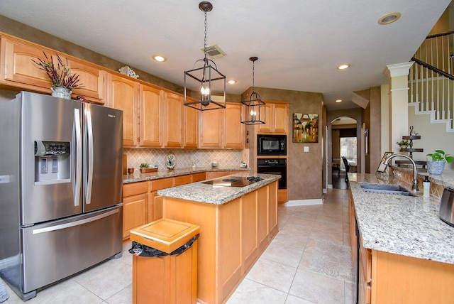 kitchen featuring visible vents, arched walkways, a kitchen island with sink, a sink, and black appliances