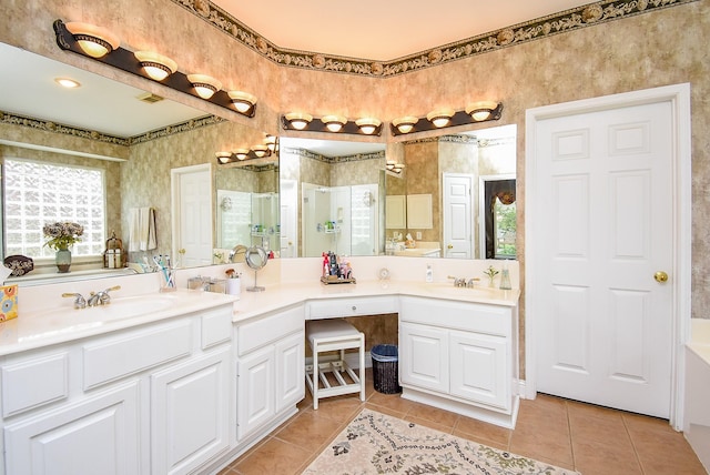 full bathroom with tile patterned flooring, a healthy amount of sunlight, a stall shower, and a sink