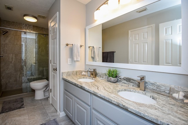 bathroom featuring visible vents, a stall shower, and a sink