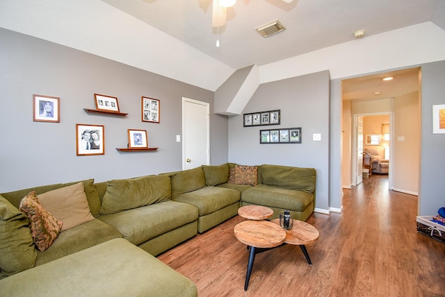 living room with wood finished floors, baseboards, visible vents, lofted ceiling, and ceiling fan