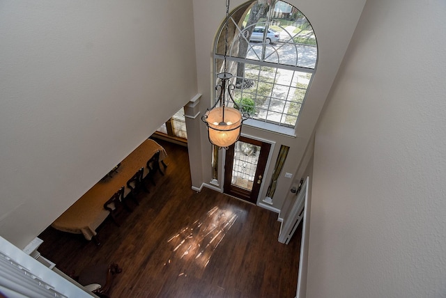 entrance foyer with baseboards, a high ceiling, and wood finished floors