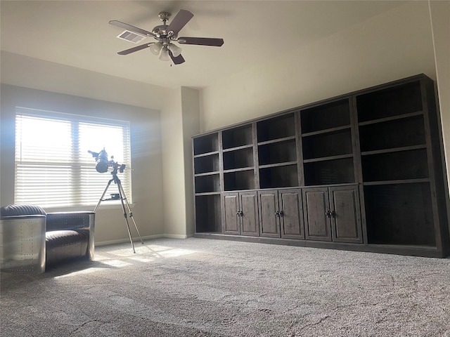 interior space with baseboards, carpet floors, and ceiling fan