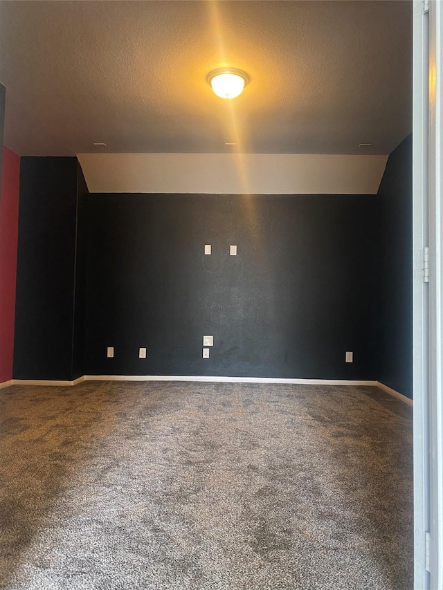 additional living space with baseboards, a textured ceiling, lofted ceiling, and carpet flooring