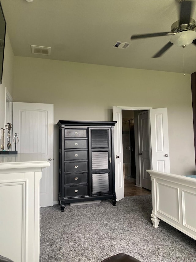 interior space featuring visible vents, a ceiling fan, and dark carpet