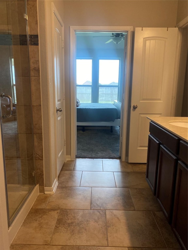 ensuite bathroom with a stall shower, vanity, ensuite bathroom, and baseboards