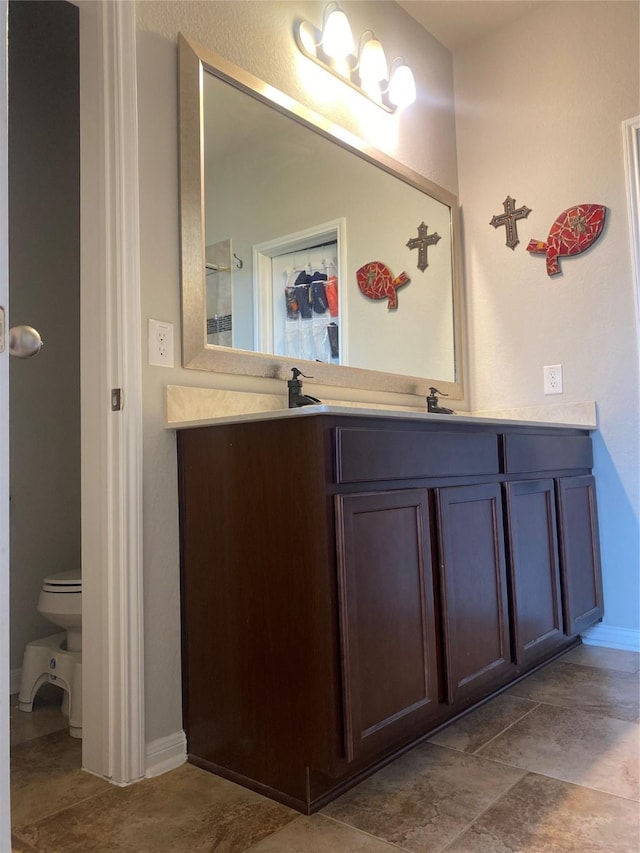 bathroom featuring double vanity and toilet