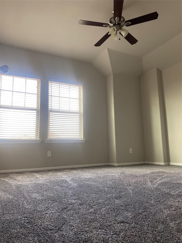 empty room featuring vaulted ceiling, baseboards, carpet, and a ceiling fan