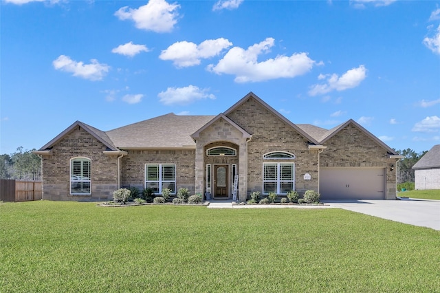 french country home featuring driveway, brick siding, a front yard, and a shingled roof