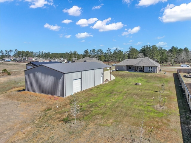 view of yard featuring an outbuilding, driveway, fence, and a garage