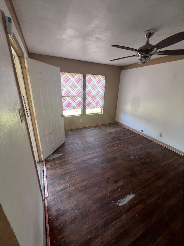 spare room featuring ceiling fan, baseboards, and wood finished floors