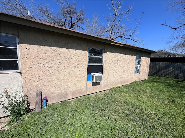 view of property exterior featuring a lawn, cooling unit, fence, and stucco siding