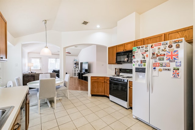 kitchen with range with gas stovetop, white refrigerator with ice dispenser, lofted ceiling, visible vents, and black microwave