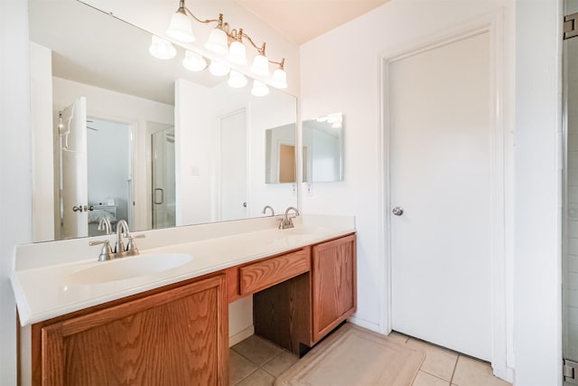 full bath featuring double vanity, a shower stall, a sink, and tile patterned floors