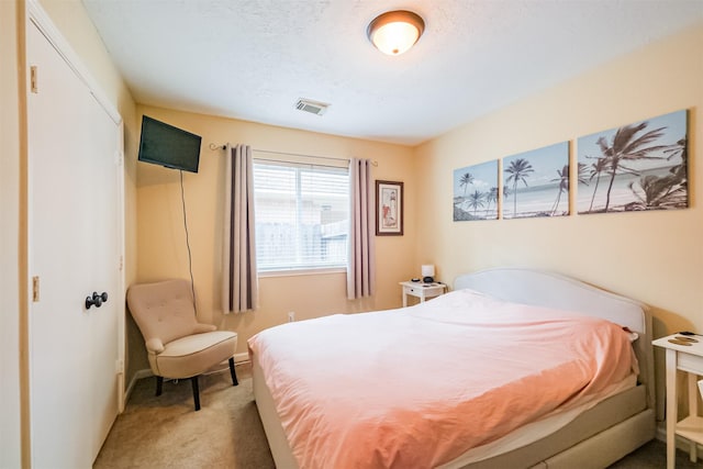 carpeted bedroom with a textured ceiling, visible vents, and baseboards