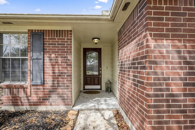 doorway to property featuring brick siding