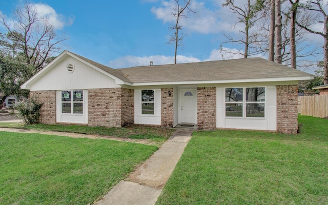 single story home with a front yard, fence, and brick siding