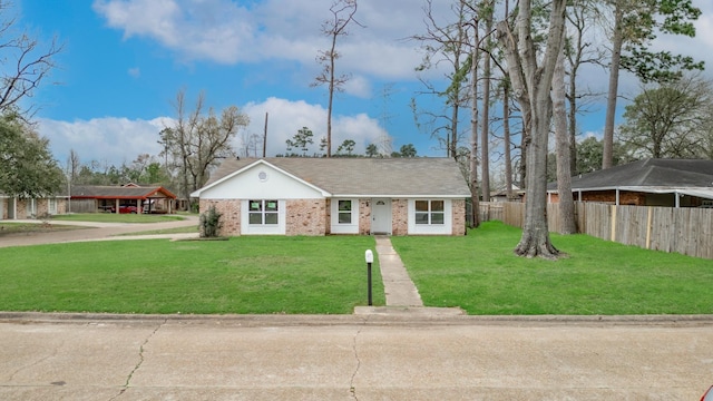 ranch-style house with brick siding, fence, and a front yard