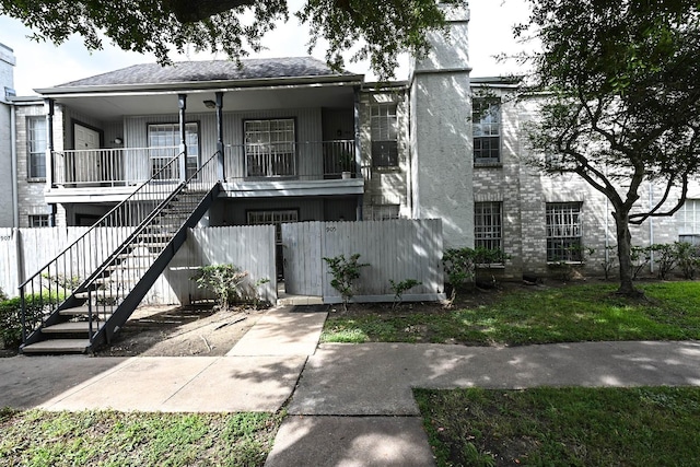 multi unit property with stairs, a porch, and fence