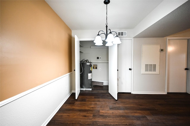 unfurnished dining area featuring water heater, visible vents, dark wood-type flooring, a chandelier, and baseboards