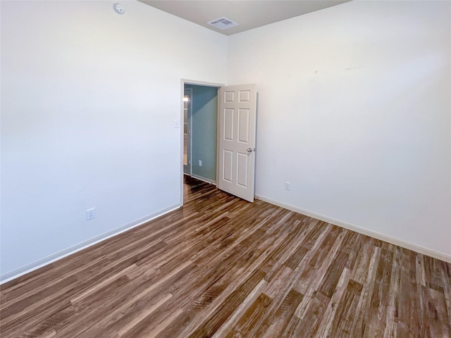 unfurnished room with wood finished floors, visible vents, and baseboards