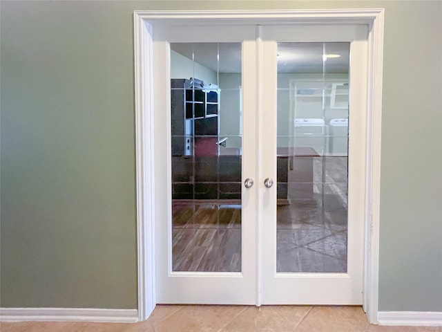 doorway with baseboards, french doors, separate washer and dryer, and tile patterned floors