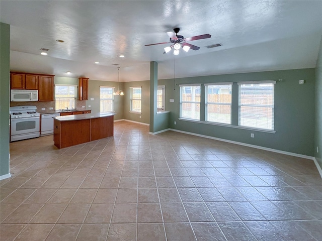 kitchen with open floor plan, white appliances, visible vents, and baseboards