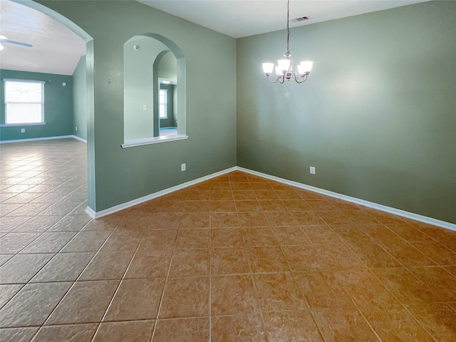 spare room featuring tile patterned flooring, a notable chandelier, arched walkways, and baseboards