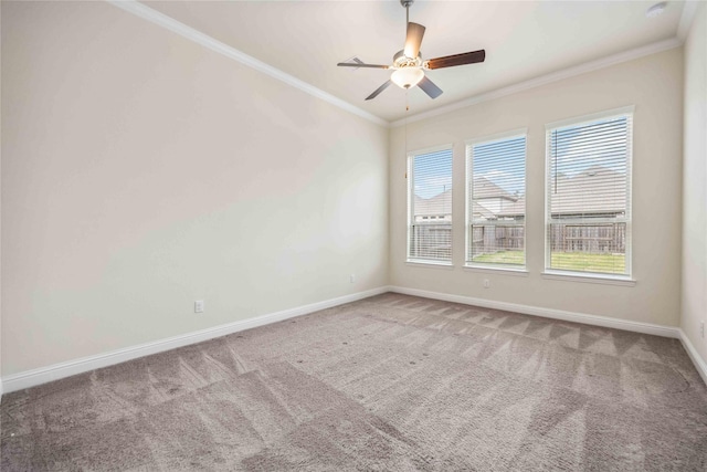 unfurnished room featuring a ceiling fan, baseboards, ornamental molding, and carpet flooring