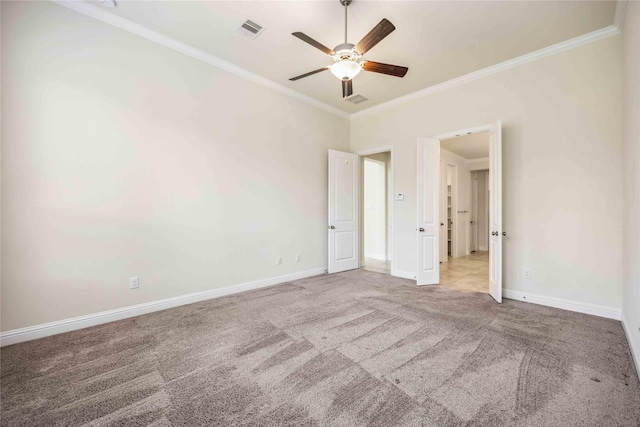 unfurnished bedroom with carpet flooring, crown molding, visible vents, and baseboards