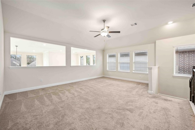 carpeted empty room featuring a ceiling fan, visible vents, vaulted ceiling, and baseboards