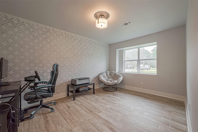 home office with light wood-style floors, visible vents, and baseboards