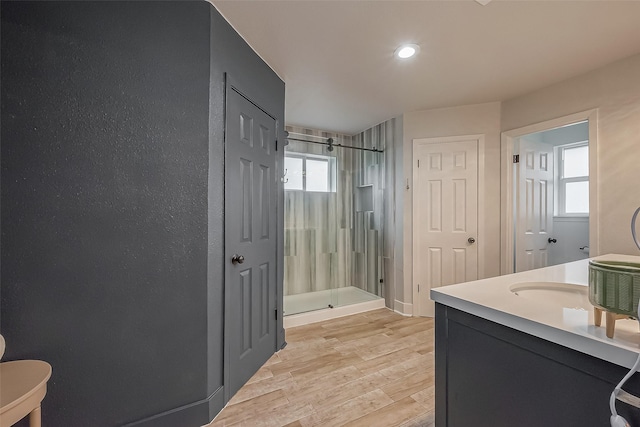 full bath with wood finished floors, a shower stall, and vanity