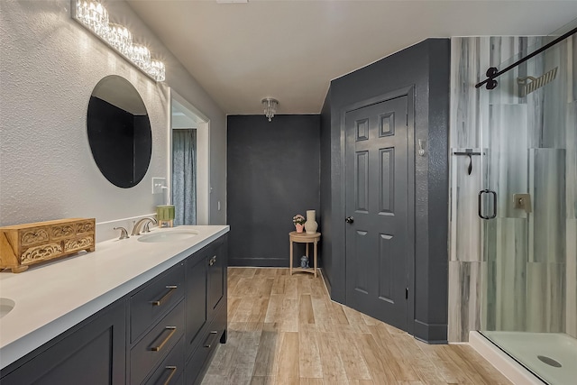 full bath with wood finished floors, vanity, and a shower stall