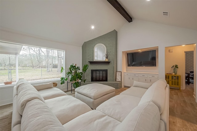 living area with high vaulted ceiling, a fireplace, baseboards, light wood-type flooring, and beam ceiling