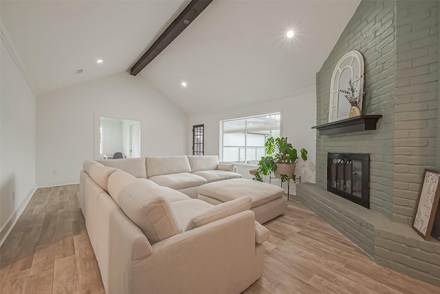 living room with a brick fireplace, baseboards, light wood finished floors, and beam ceiling