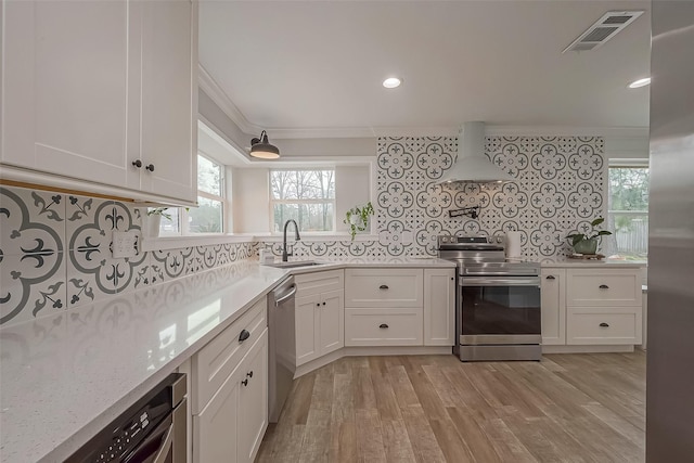 kitchen featuring stainless steel appliances, a sink, visible vents, ornamental molding, and custom range hood