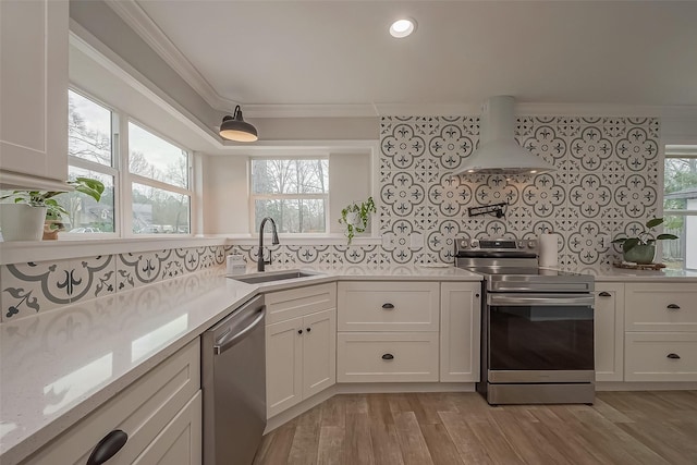 kitchen featuring stainless steel appliances, custom range hood, decorative backsplash, ornamental molding, and a sink