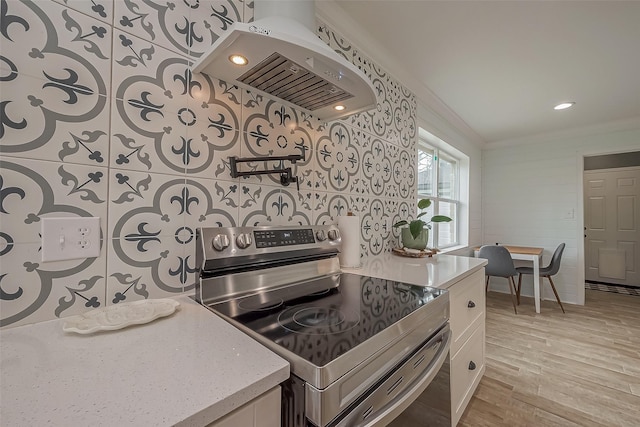 kitchen with crown molding, light wood-style floors, white cabinetry, stainless steel electric range, and extractor fan