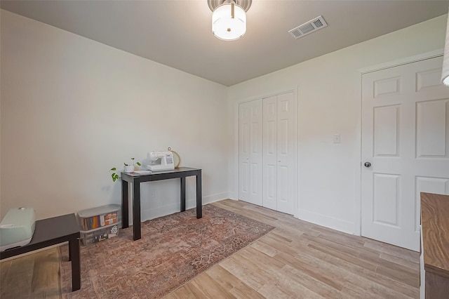 office area with visible vents, baseboards, and wood finished floors