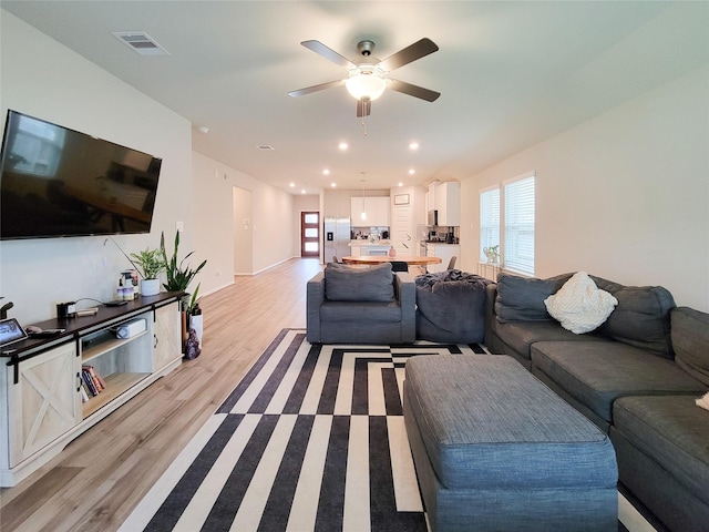 living area featuring light wood finished floors, visible vents, baseboards, ceiling fan, and recessed lighting