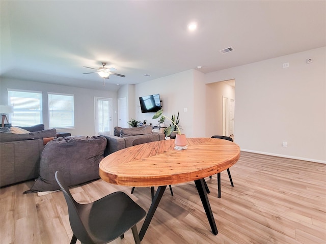 dining room featuring a ceiling fan, light wood-type flooring, visible vents, and baseboards