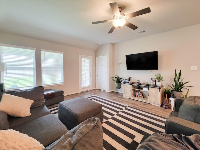 living area with a ceiling fan, visible vents, and wood finished floors