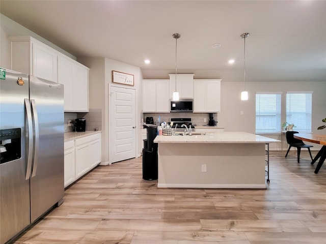 kitchen featuring stainless steel appliances, light wood-type flooring, and white cabinetry