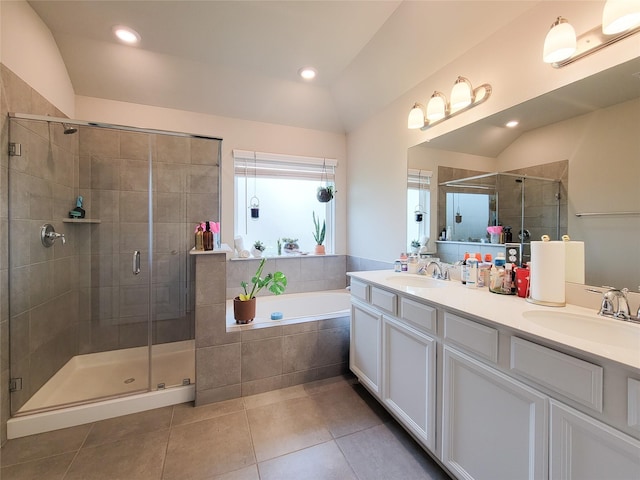 bathroom with a stall shower, lofted ceiling, a sink, and tile patterned floors