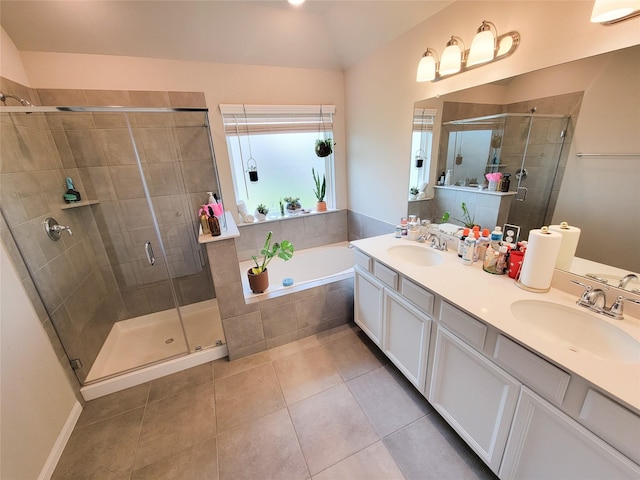 bathroom featuring a garden tub, a shower stall, a sink, and tile patterned floors